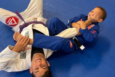 Instructor training on the mat with a young student in a Little Champions 2 class, Fleming Island FL